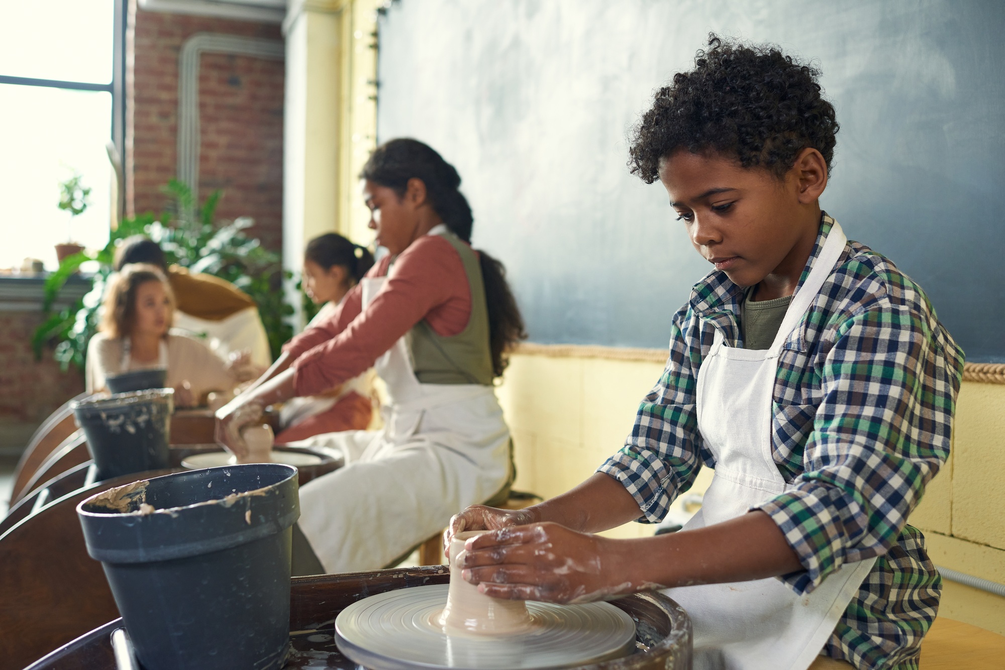 cute-african-schoolboy-in-apron-sculpting-earthenware.jpg