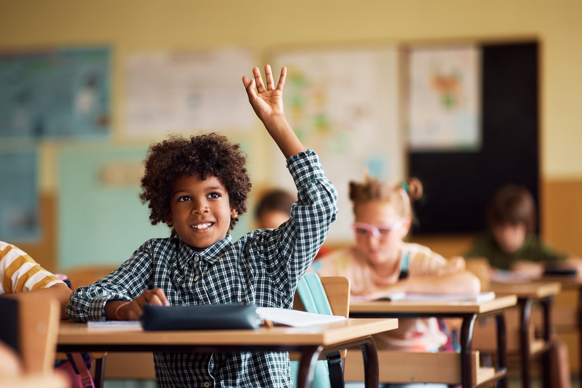 happy-african-american-kid-raising-his-arm-to-ask-a-question-during-a-class-at-elementary-school-.jpg